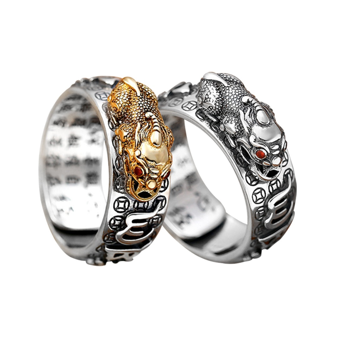 Anel Feng Shui prateado com símbolo de Pixiu dourado e prata, decorado com detalhes em relevo de mantra, Pelicano Azul.