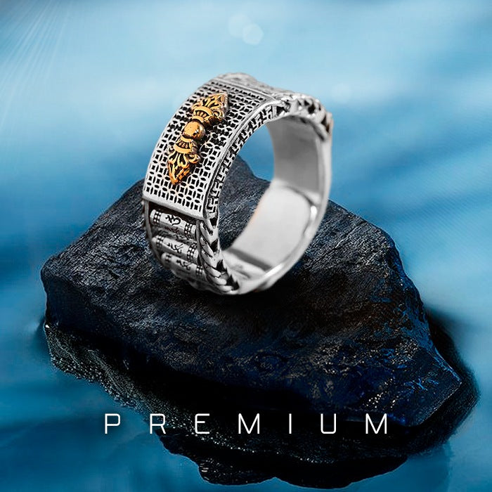 Anel prateado com símbolo dourado de Vajra e padrões gravados em estilo Feng Shui, Pelicano Azul.