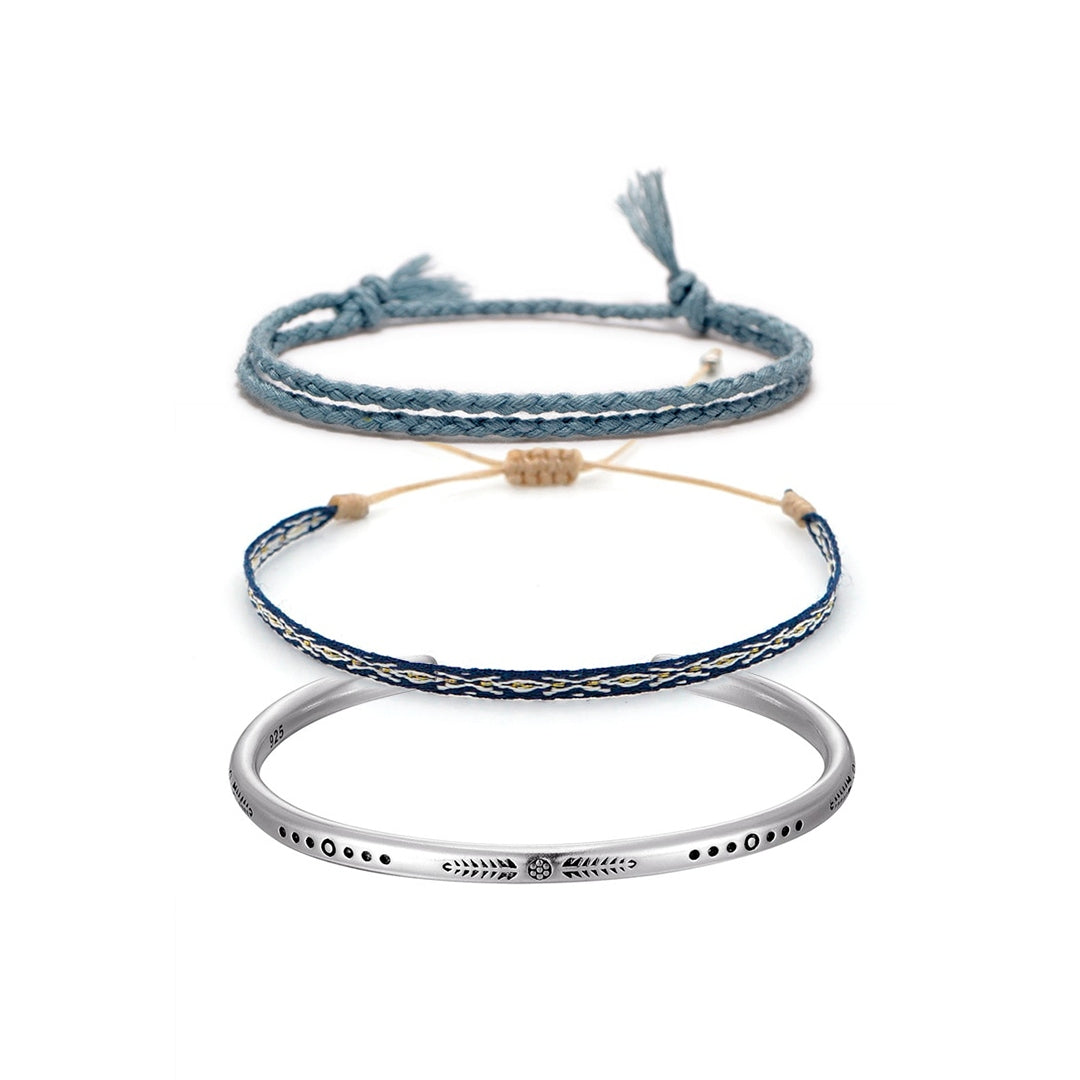 Conjunto com duas pulseiras em corda azul clara e escura, e bracelete de prata tibetana gravado, simbolizando calma, equilíbrio e cura espiritual - Pelicano Azul