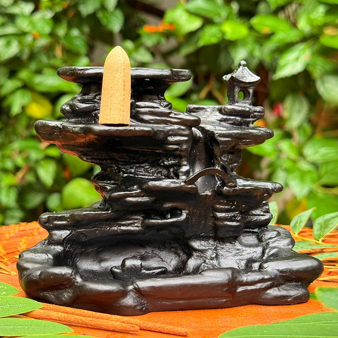 Incensário Cachoeira de Rozan Pelicano Azul em preto, com detalhes esculpidos de cascata e pagode.