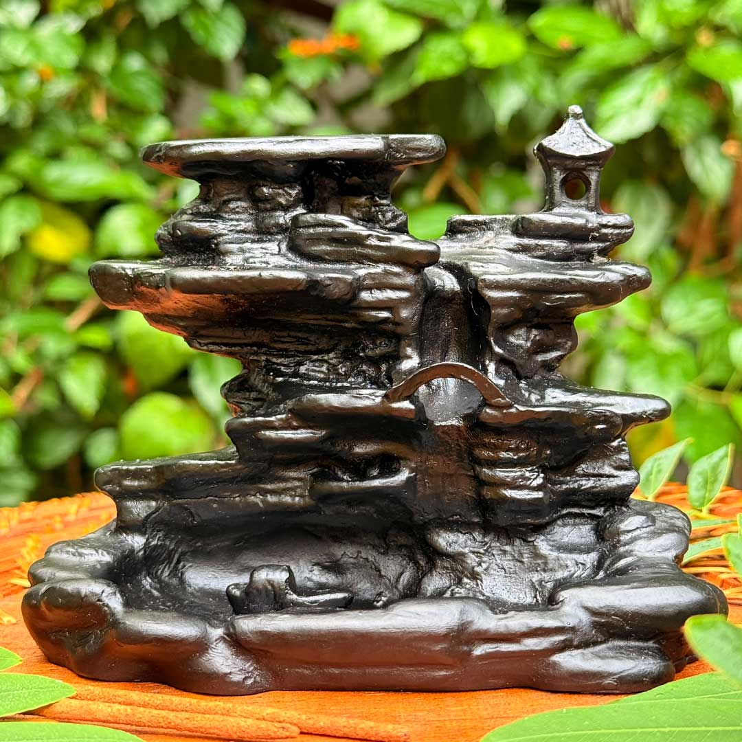 Incensário Cachoeira de Rozan preto, design de cascata com pagode no topo, fotografado ao ar livre.
