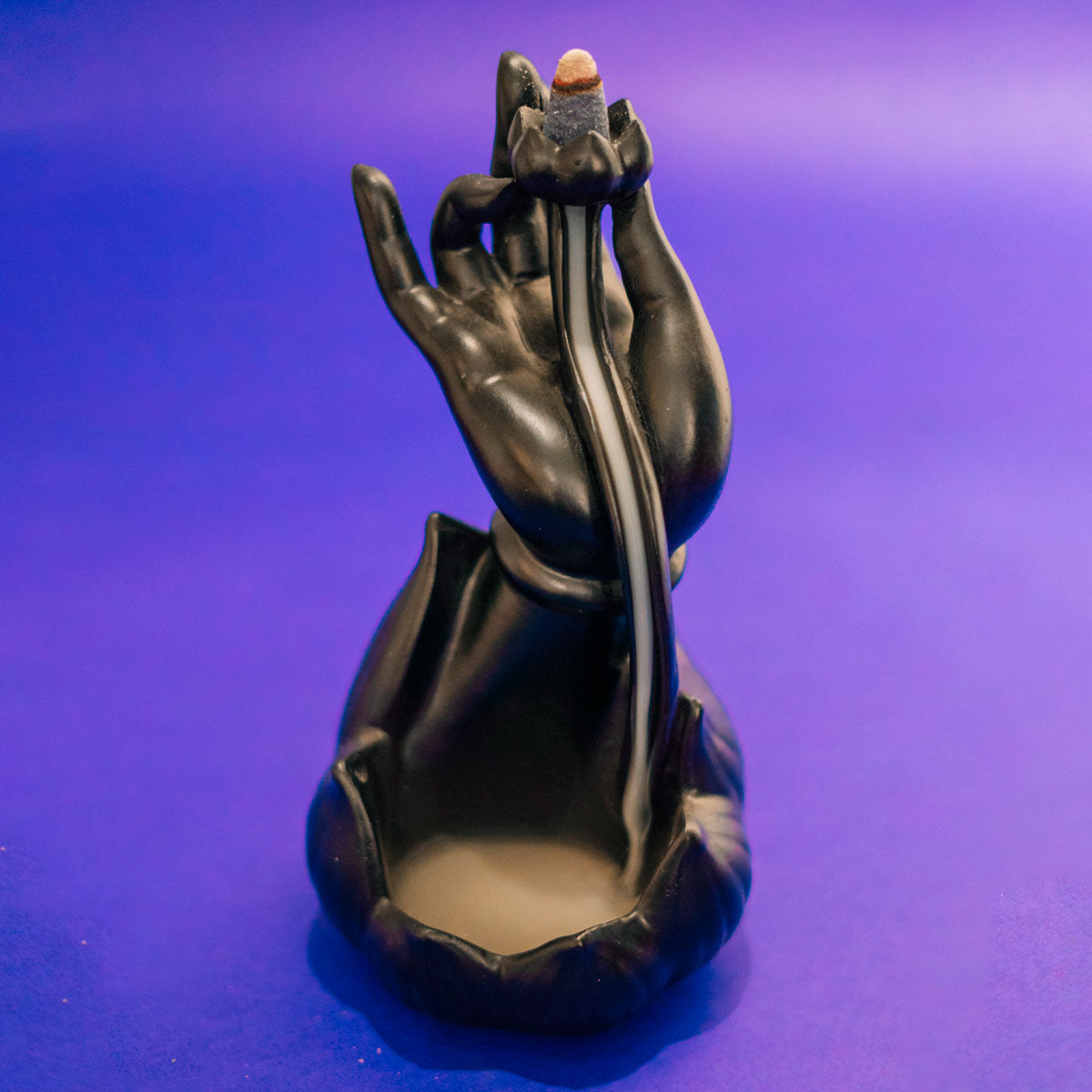 Incensário Mudra da Iluminação em cerâmica preta, representando mão budista com fluxo reverso de fumaça, trazendo paz e equilíbrio Pelicano Azul.