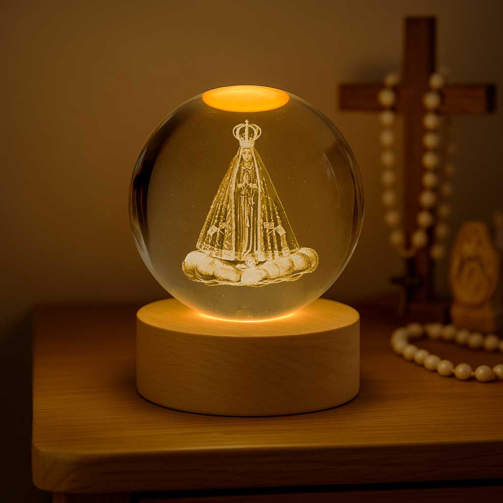 Luminária religiosa com imagem da santa em esfera de vidro iluminada sobre base de madeira.