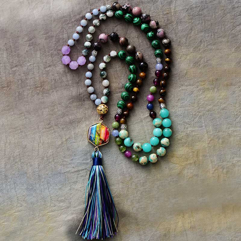 Japamala da Ativação dos 7 Chakras com pedras naturais em tons vibrantes e pingente multicolorido, finalizado com um tassel azul e verde Pelicano Azul.