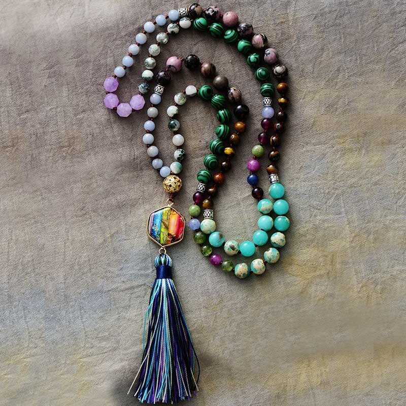 Japamala da Ativação dos 7 Chakras com pedras naturais em tons vibrantes e pingente multicolorido, finalizado com um tassel azul e verde Pelicano Azul.