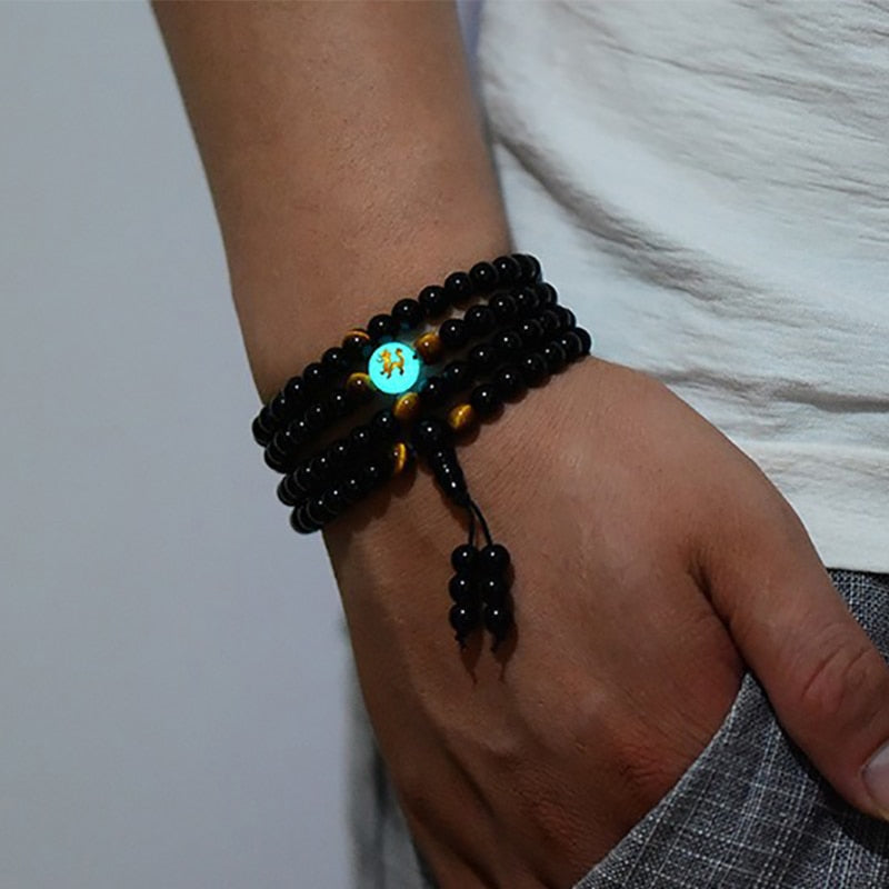 Japamala Pulseira Ônix Negro com 108 Contas, destacando um design elegante e minimalista com detalhes em olho de tigre. Ideal para práticas meditativas e equilíbrio espiritual. Pelicano Azul.