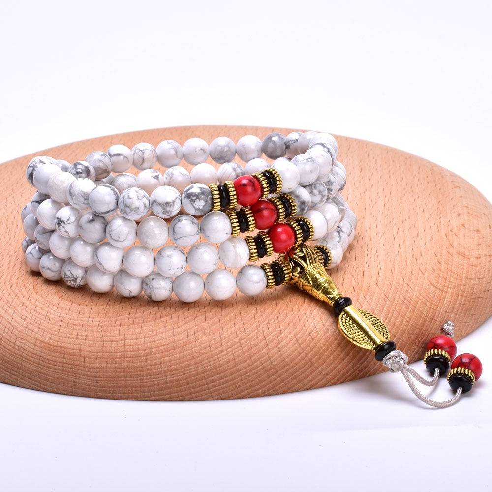 Japamala Tibetano com 108 Contas de Howlita e Turquesa Vermelha, perfeito para acalmar as emoções, em um design elegante e harmonioso Pelicano Azul.