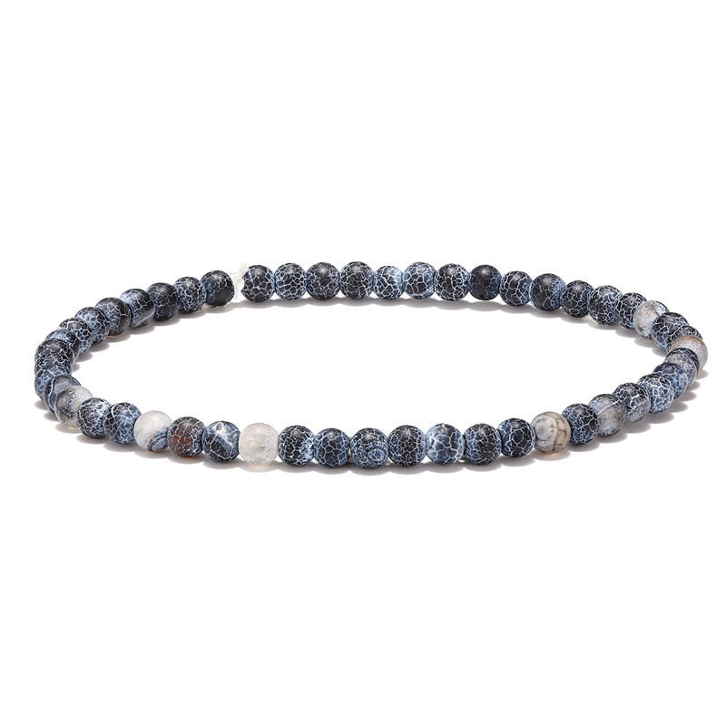 Pulseira de contas de pedra em tons de azul e branco, parte do Conjunto Budista da Coragem.
