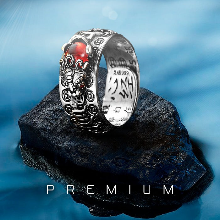Anel prateado com pedra de granada vermelha e detalhes de dragão gravados, estilo Feng Shui, Pelicano Azul.