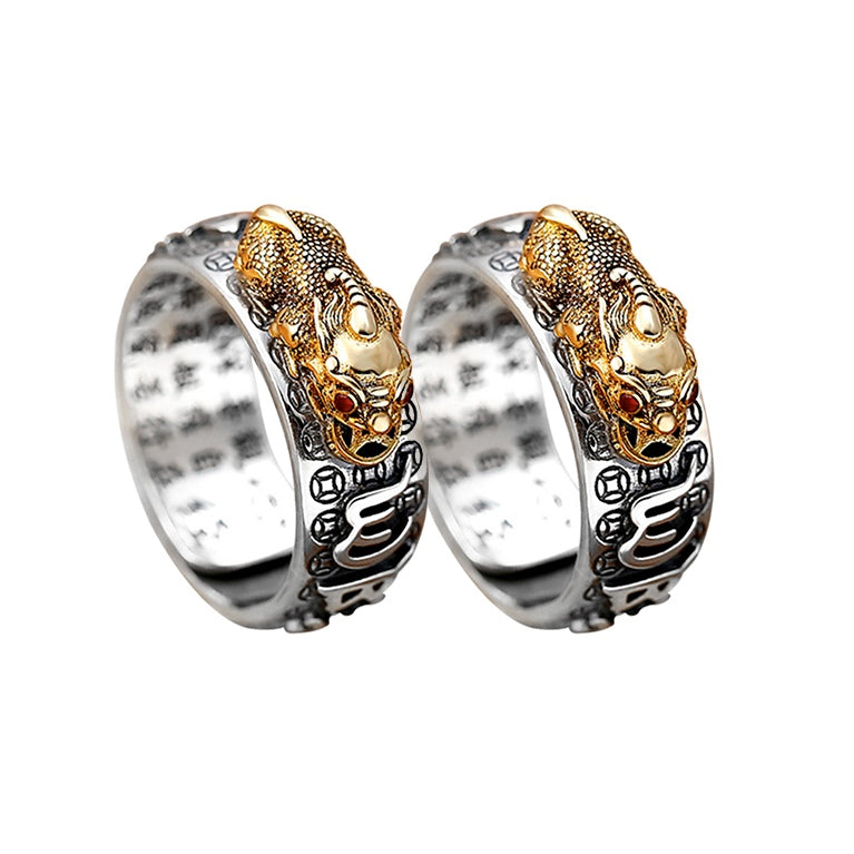 Anel Feng Shui prateado com símbolo de Pixiu dourado e detalhes em relevo de mantra, Pelicano Azul.