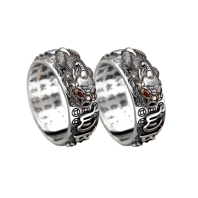 Anel Feng Shui prateado com detalhes em relevo de mantra e símbolo de Pixiu, Pelicano Azul.