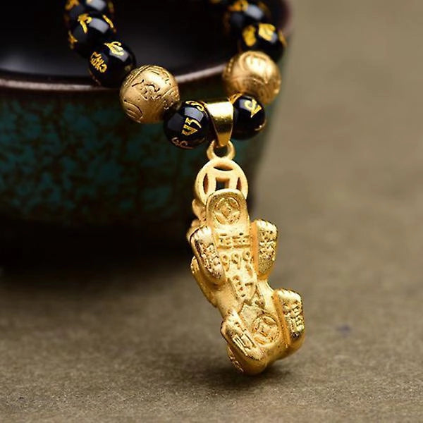 Colar de obsidiana negra com contas decoradas e pingente de Pixiu dourado, símbolo de proteção e prosperidade no Feng Shui. Pelicano Azul.