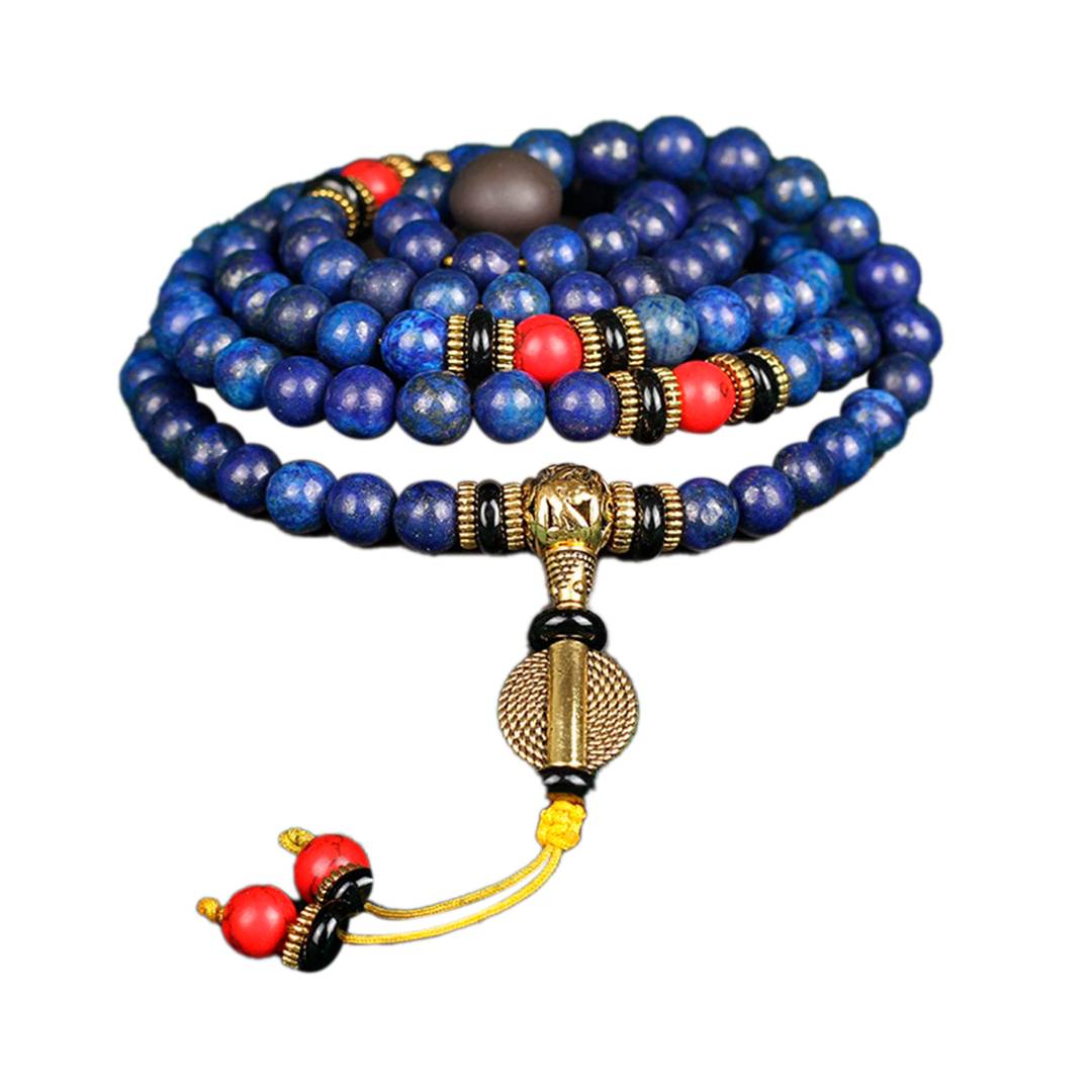Japamala tibetano com 108 contas em lápis-lazúli azul, com detalhes em turquesa vermelha e amuleto dourado. Ideal para meditação e elevação espiritual, Pelicano Azul.