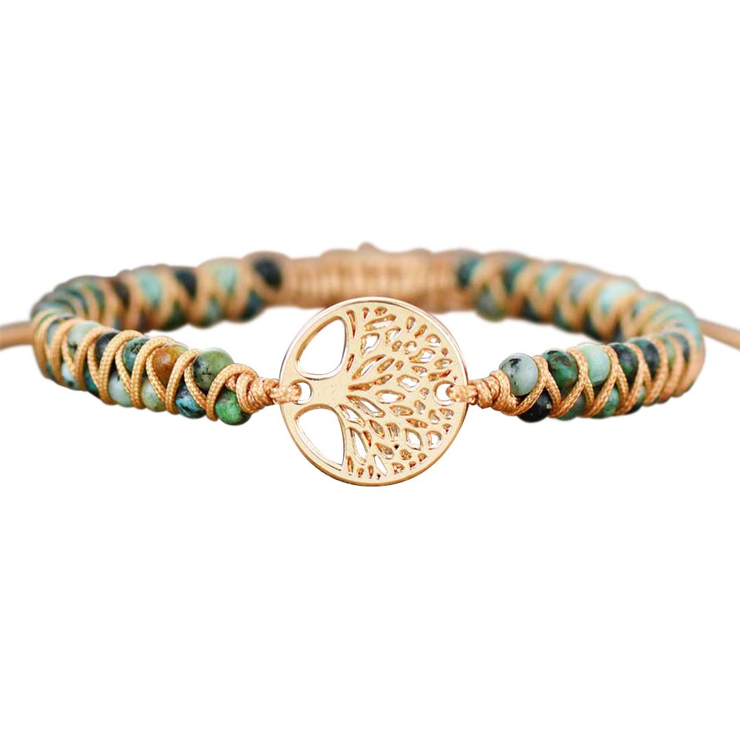 Pulseira com contas de turquesa africana em tons naturais, entrelaçada com cordão dourado e um pingente central em formato de árvore da vida, Pelicano Azul.