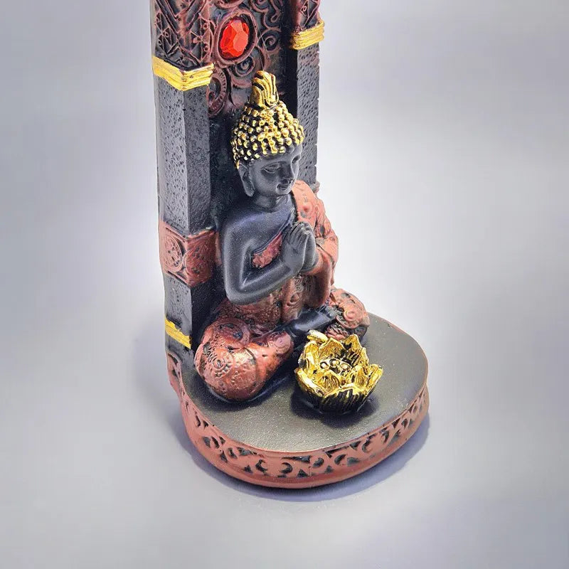 Base do incensário com Buda orando e flor dourada decorativa em detalhe próximo - Pelicano Azul