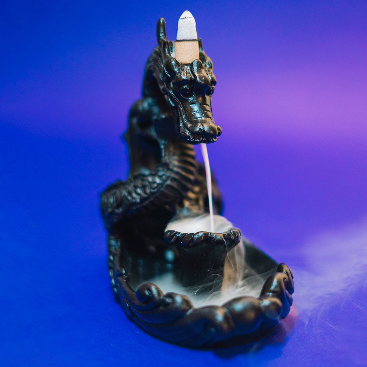 Incensário Cascata Dragão Celestial em cerâmica preta, com design místico e fluxo de fumaça suave, trazendo proteção e harmonia Pelicano Azul.