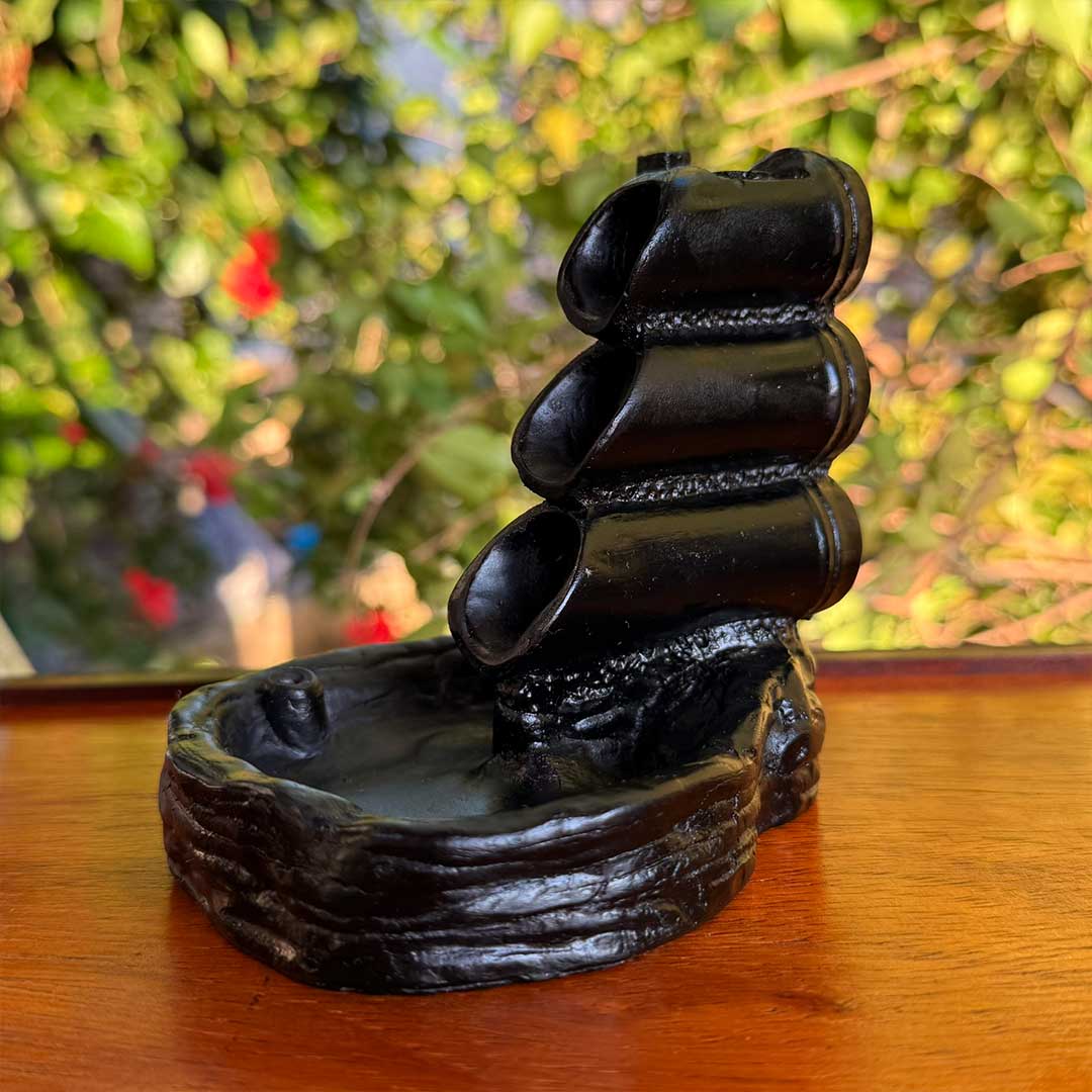 Incensário Cascata Shizen Pelicano Azul, design rústico em cerâmica preta, ideal para defumação e relaxamento.