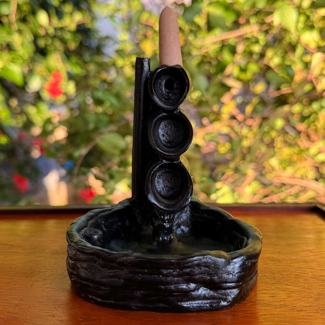 Incensário Cascata Shizen Pelicano Azul, com design rústico em formato de cachoeira e cone de incenso no topo, destacando detalhes esculpidos.