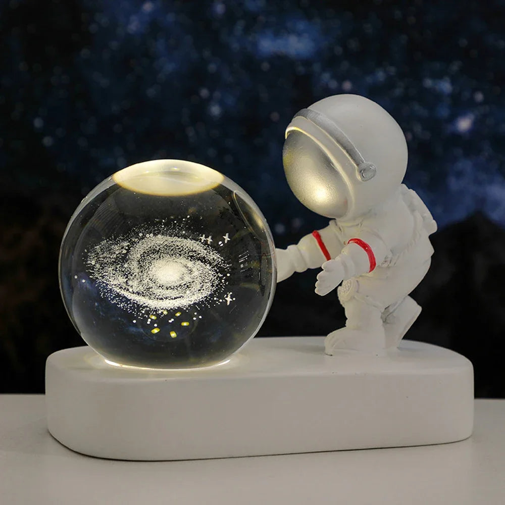 Luminária Planetária Astronauta com esfera iluminada exibindo uma galáxia, ideal para decoração espacial e ambientes aconchegantes.