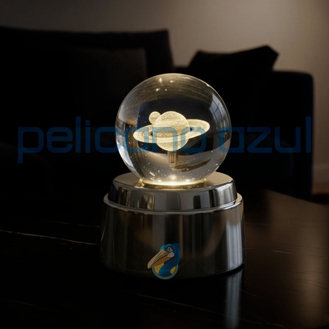 luminária giratória com planeta saturno iluminado sobre base metálica brilhante