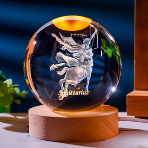 Luminária de cristal com o signo de sagitário gravado em 3D, iluminada por LED, criando um efeito celestial. Ideal para representar o equilíbrio e a harmonia do signo de sagitário. Pelicano Azul.