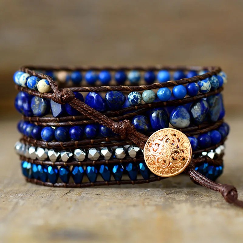 Pulseira de lápis-lazúli artesanal, com pedras azuis e fecho dourado detalhado, ajustável com fios de couro.