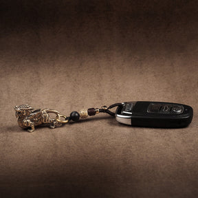 Chaveiro da sorte com Pixiu protetor em bronze, acompanhado de chaves, símbolo de proteção e prosperidade, Pelicano Azul.