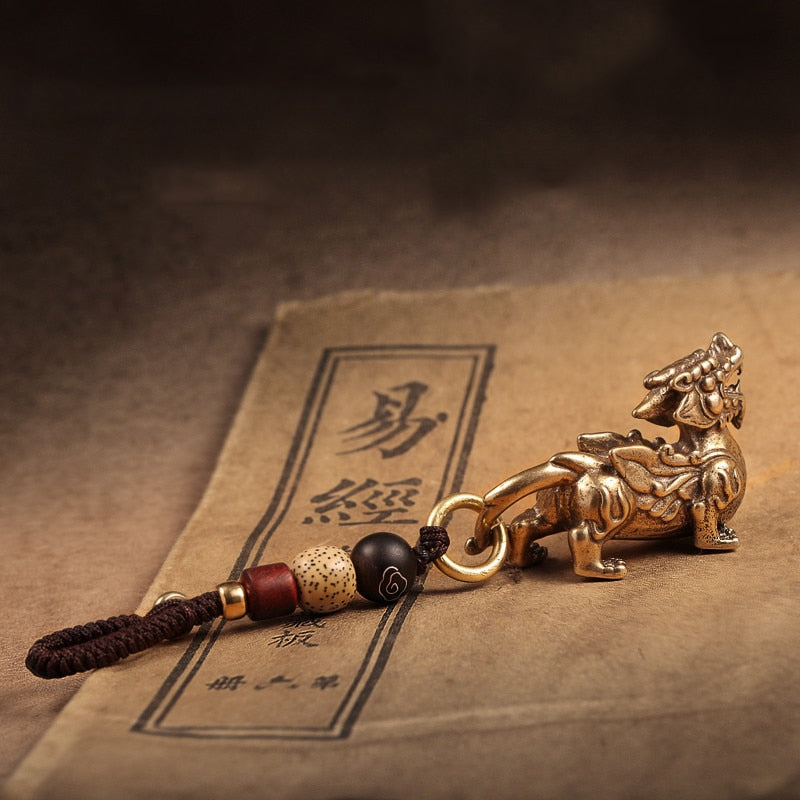 Chaveiro da Sorte com figura de Pixiu dourado e detalhes de contas, amuleto protetor, Pelicano Azul.