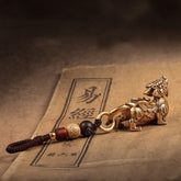 Chaveiro da Sorte com figura de Pixiu dourado e detalhes de contas, amuleto protetor, Pelicano Azul.